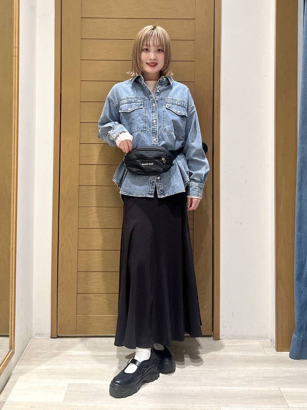 ブルー系のシャツ/ブラウス、ブラック系のスニーカー、ピンク系のニット/セーターを着用したレディースの春コーディネートの6枚目の写真