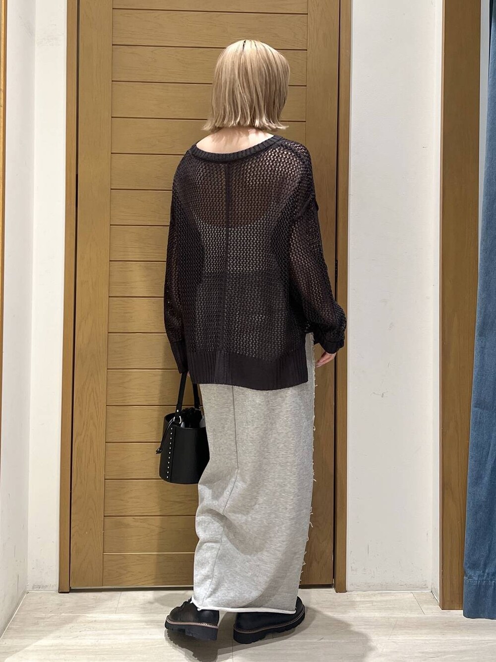 ブラック系のハンドバッグ、グレー系のスカート、ブラック系のローファーを着用したレディースの春コーディネートの5枚目の写真