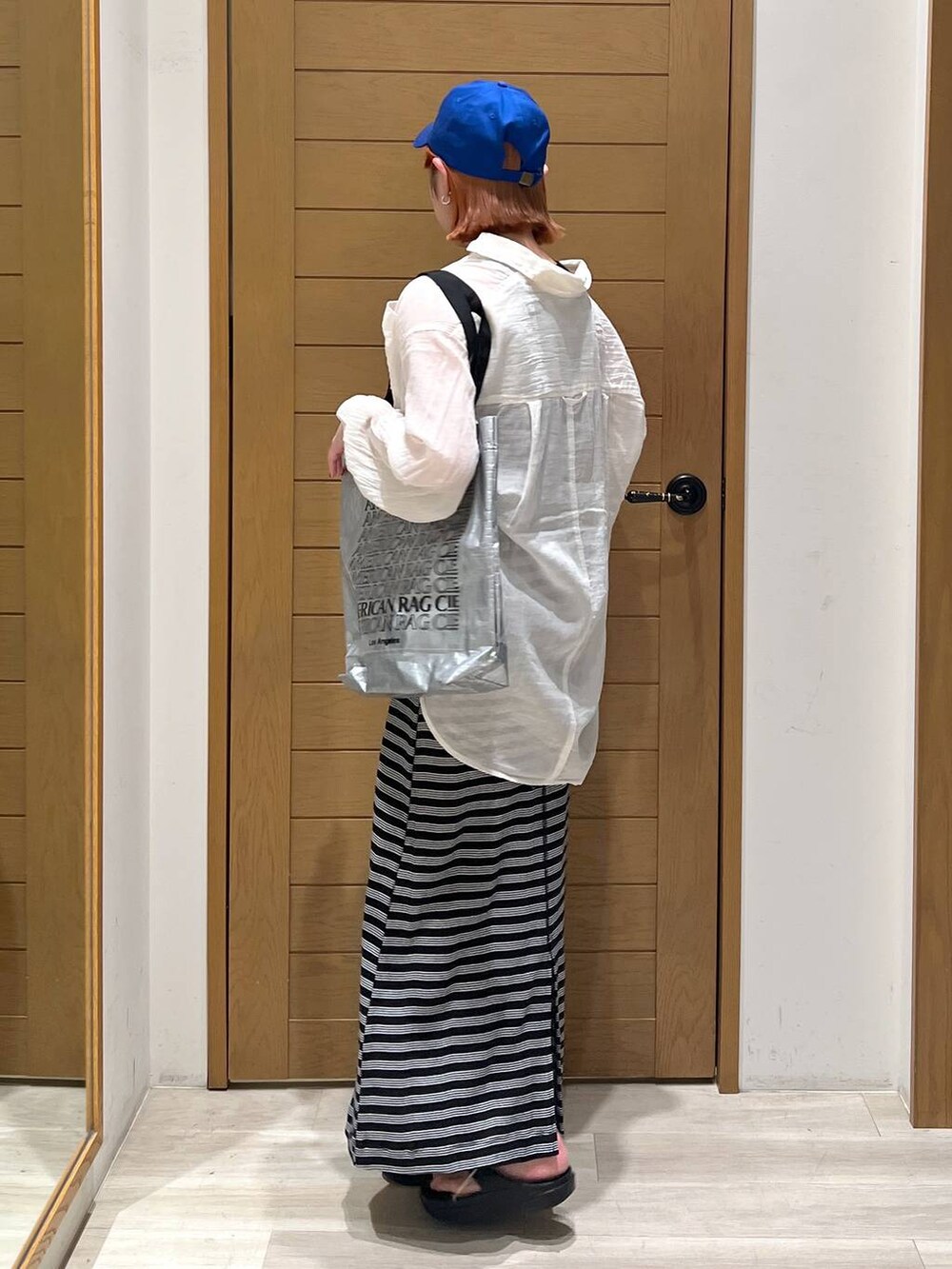 ブラック系のサンダル、ホワイト系のシャツ/ブラウス、シルバー系のトートバッグを着用したレディースの夏コーディネートの3枚目の写真