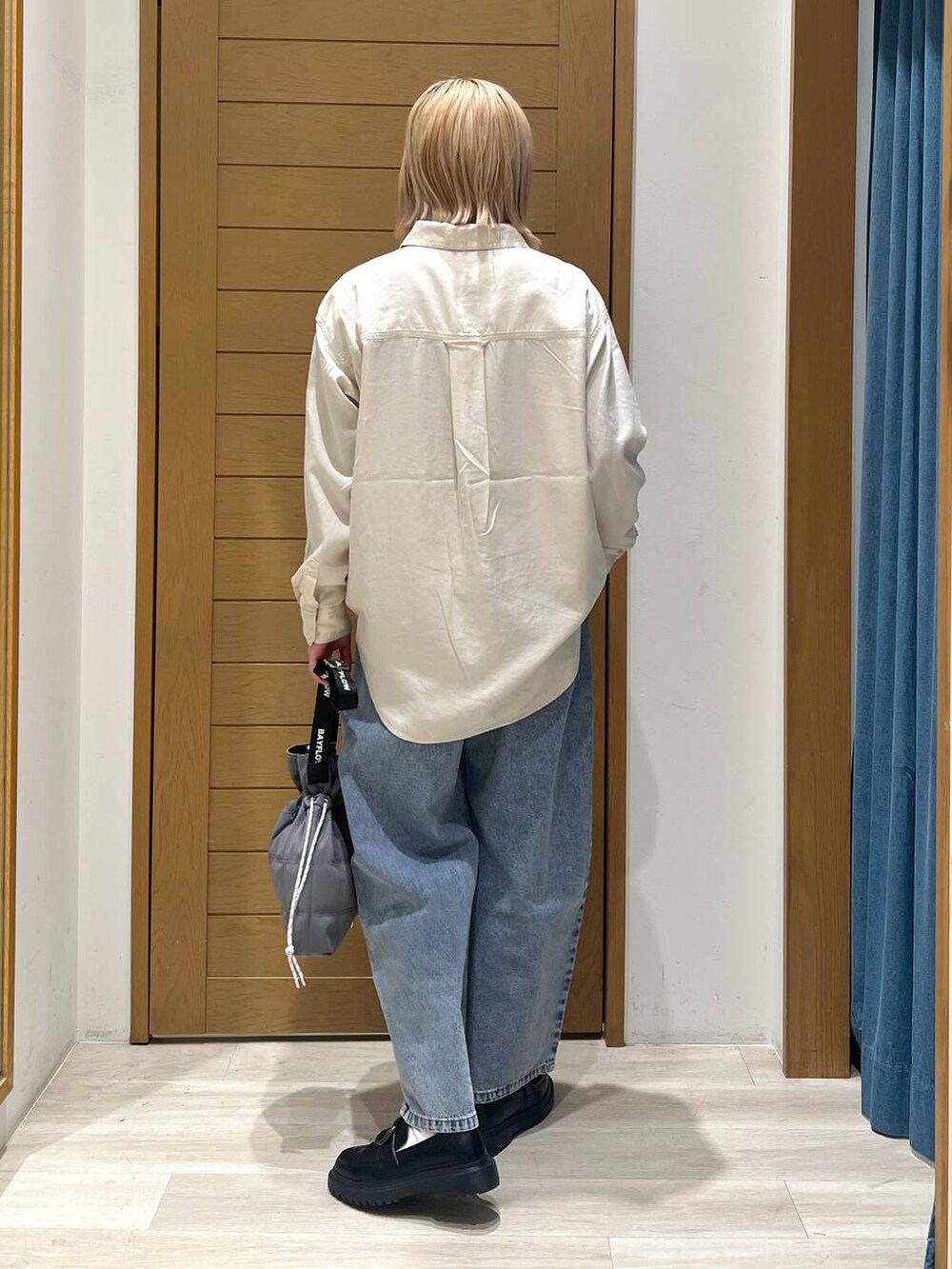 ホワイト系のシャツ/ブラウス、ブルー系のデニムパンツ、その他のローファーを着用したレディースの冬コーディネートの4枚目の写真