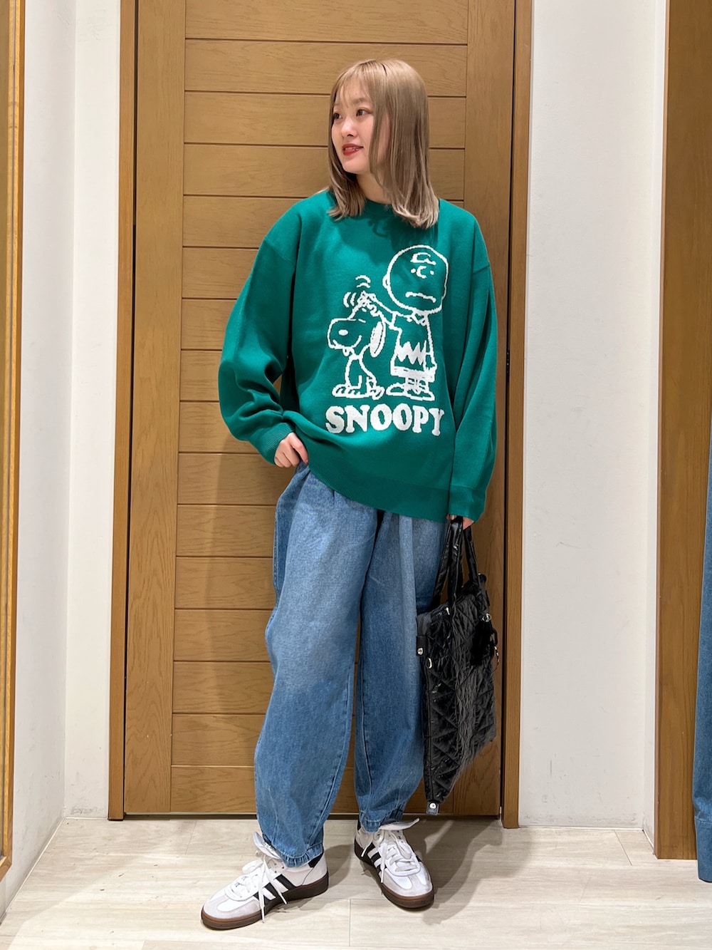 パープル系のニット/セーター、ブルー系のデニムパンツ、ブラック系のトートバッグを着用したレディースの冬コーディネートの3枚目の写真