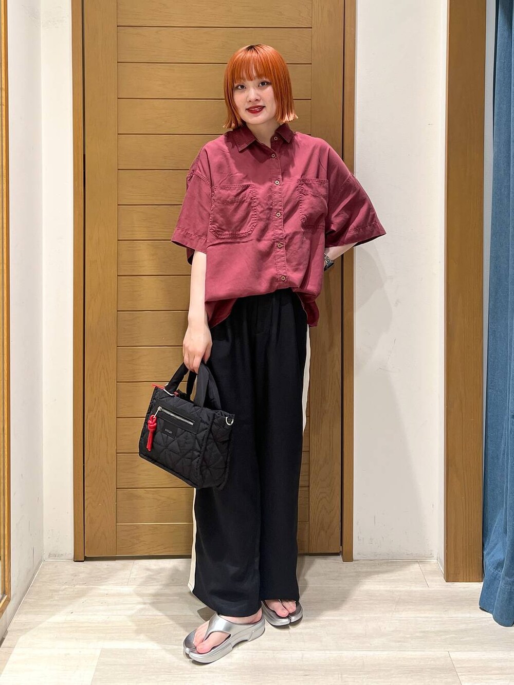 シルバー系のサンダル、レッド系のシャツ/ブラウス、ブラック系のショルダーバッグを着用したレディースの夏コーディネートの2枚目の写真