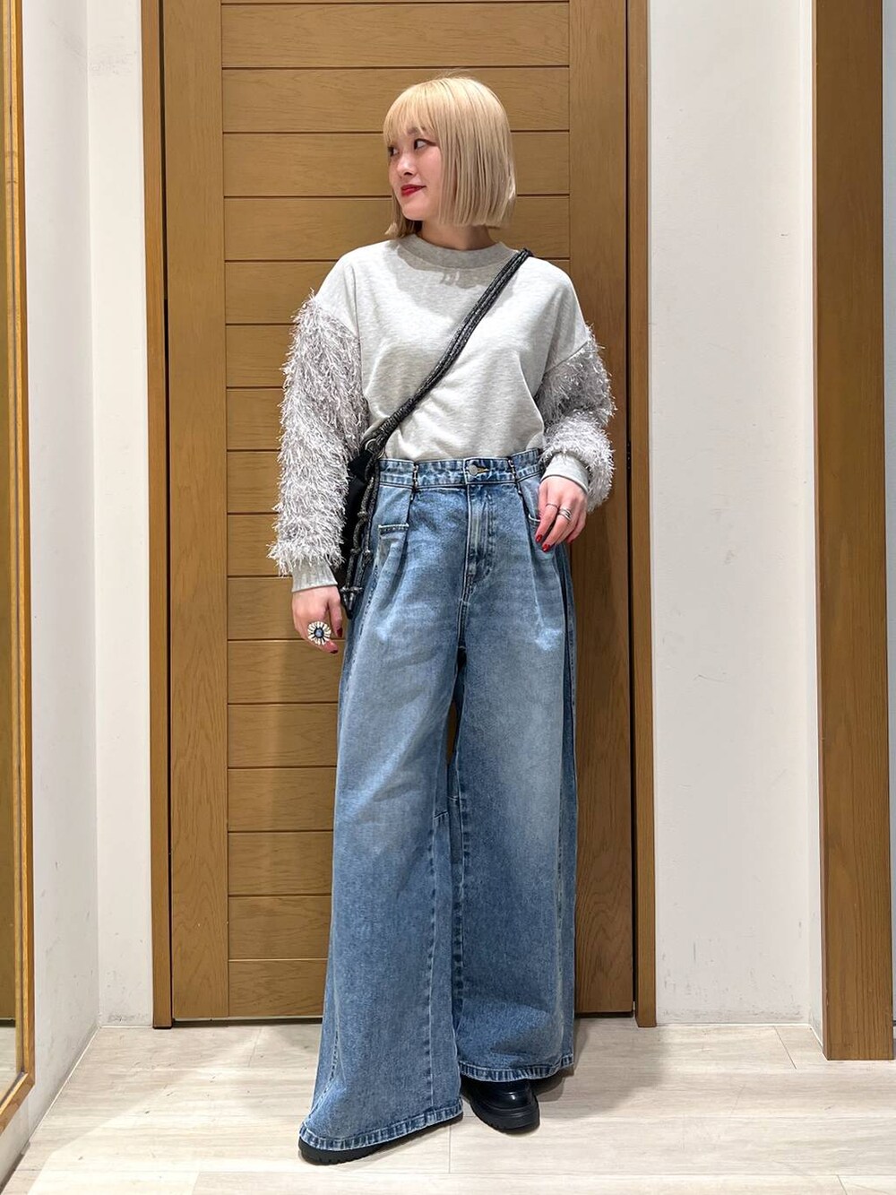 ブルー系のデニムパンツ、その他のローファー、ブラック系のショルダーバッグを着用したレディースの冬コーディネートの2枚目の写真