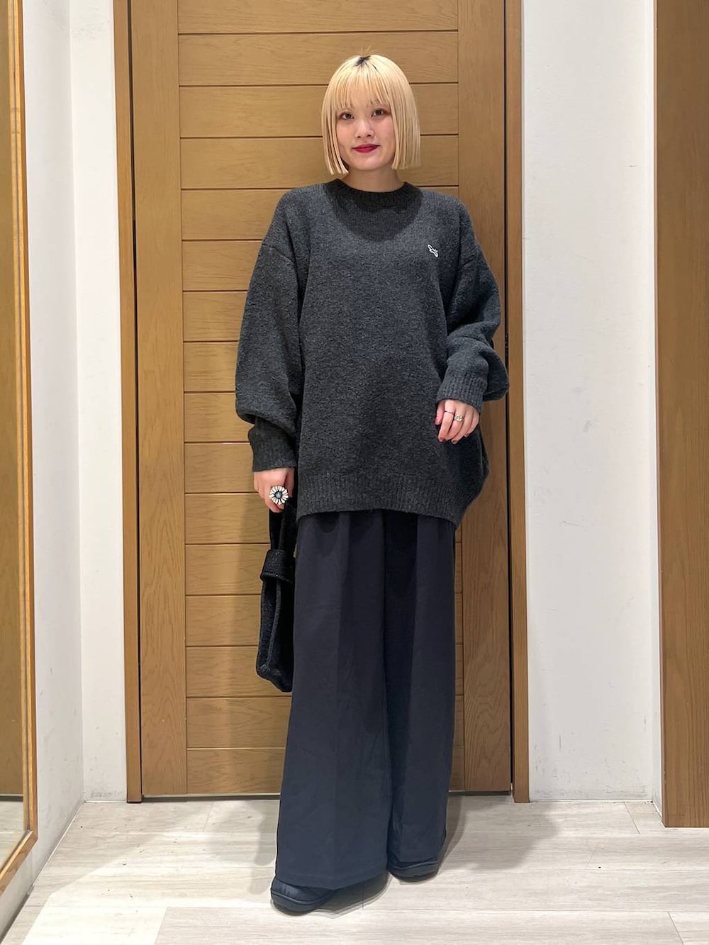 ブラック系のその他パンツ、グレー系のニット/セーター、ブラック系のハンドバッグを着用したレディースの冬コーディネートの3枚目の写真