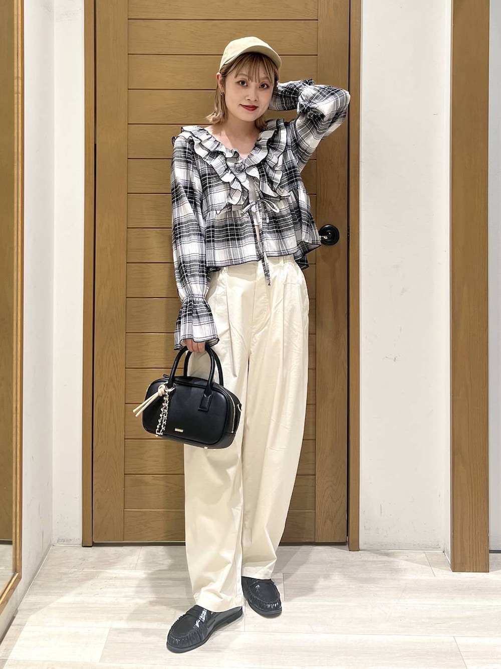 ホワイト系のその他パンツ、ブラック系のハンドバッグ、ブラック系のシャツ/ブラウスを着用したレディースの春コーディネートの2枚目の写真