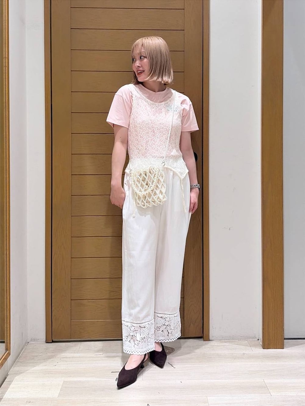 その他のショルダーバッグ、ブラウン系のパンプス、ホワイト系のタンクトップを着用したレディースの夏コーディネートの2枚目の写真