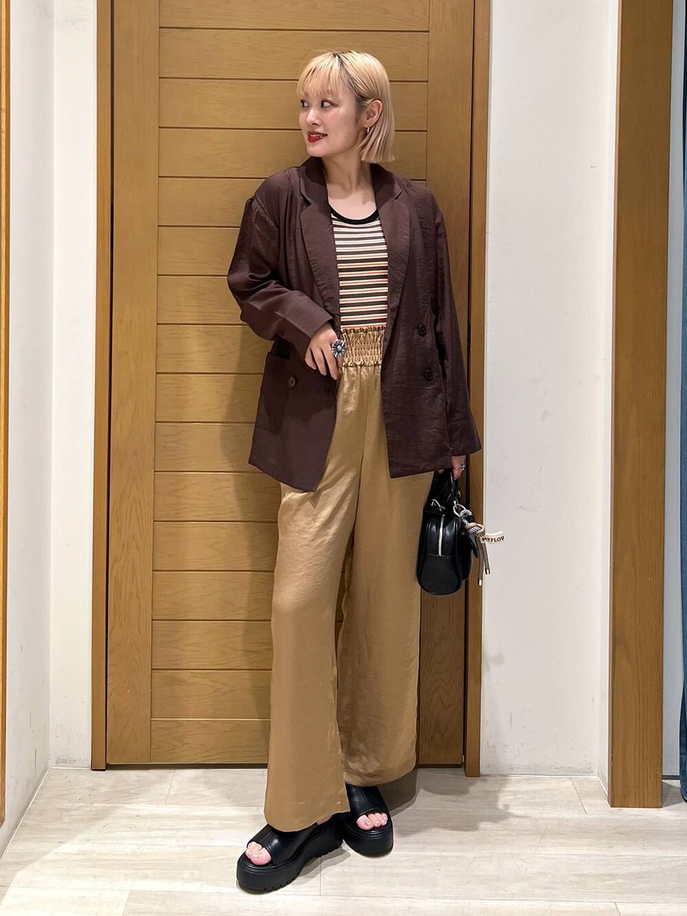 ブラック系のボストンバッグ、ブラウン系のその他パンツ、ブラウン系のテーラードジャケットを着用したレディースの夏コーディネートの2枚目の写真