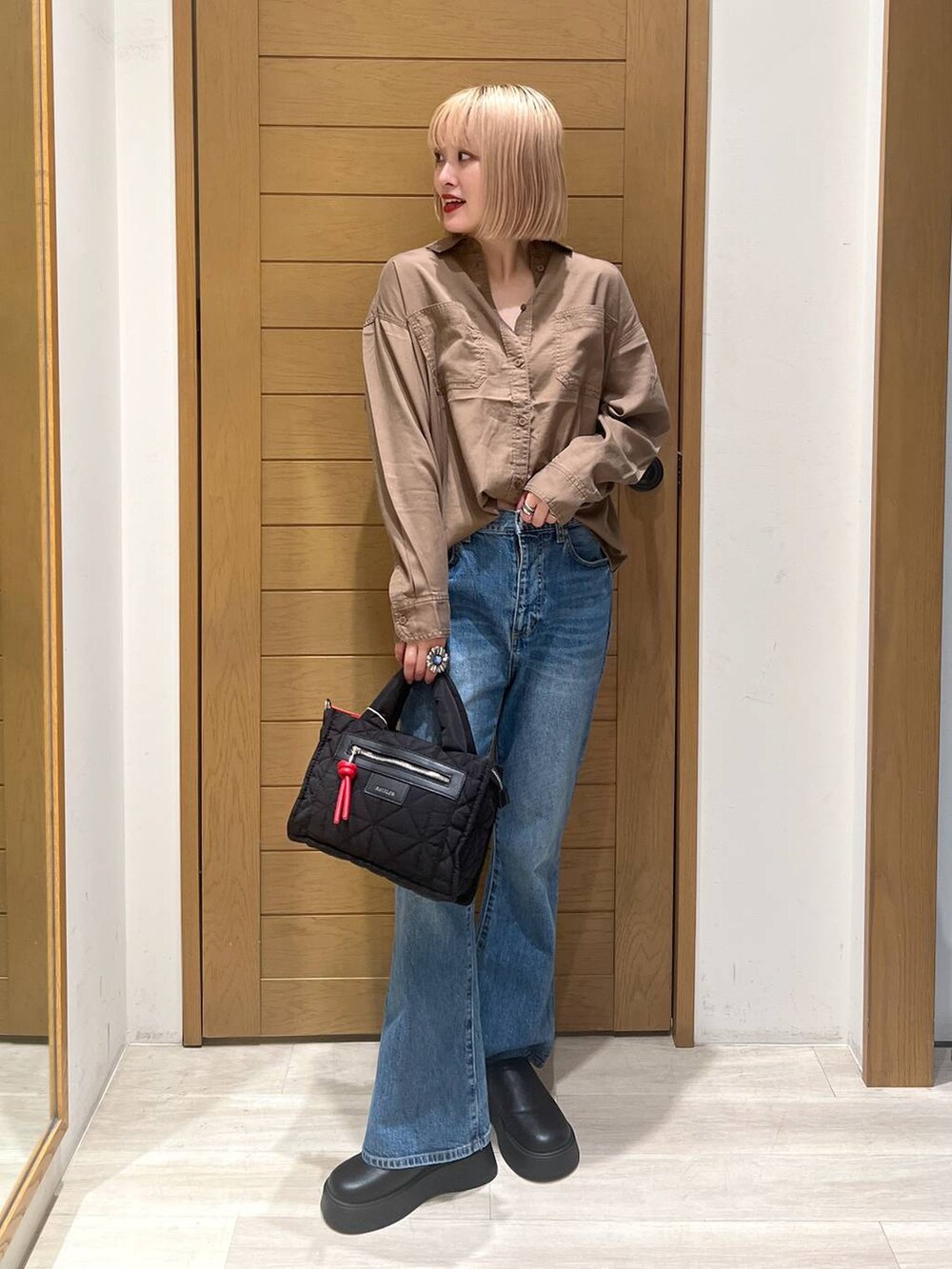 ブラック系のショルダーバッグ、ブラウン系のシャツ/ブラウス、ブルー系のデニムパンツを着用したレディースの夏コーディネートの2枚目の写真