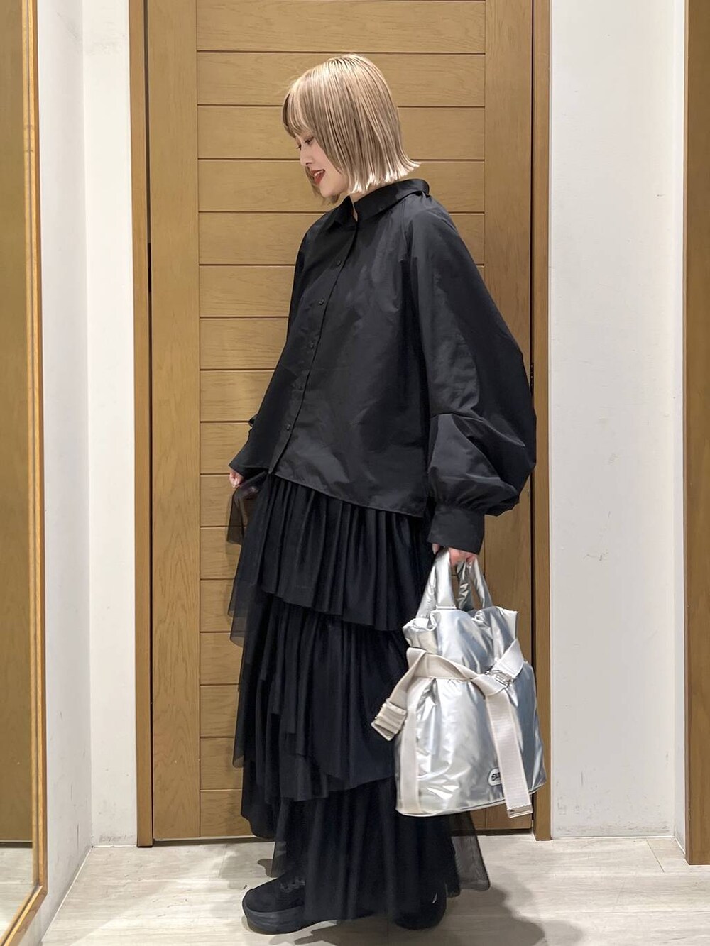 シルバー系のトートバッグ、ブラック系のシャツ/ブラウス、ブラック系のスカートを着用したレディースの春コーディネートの5枚目の写真