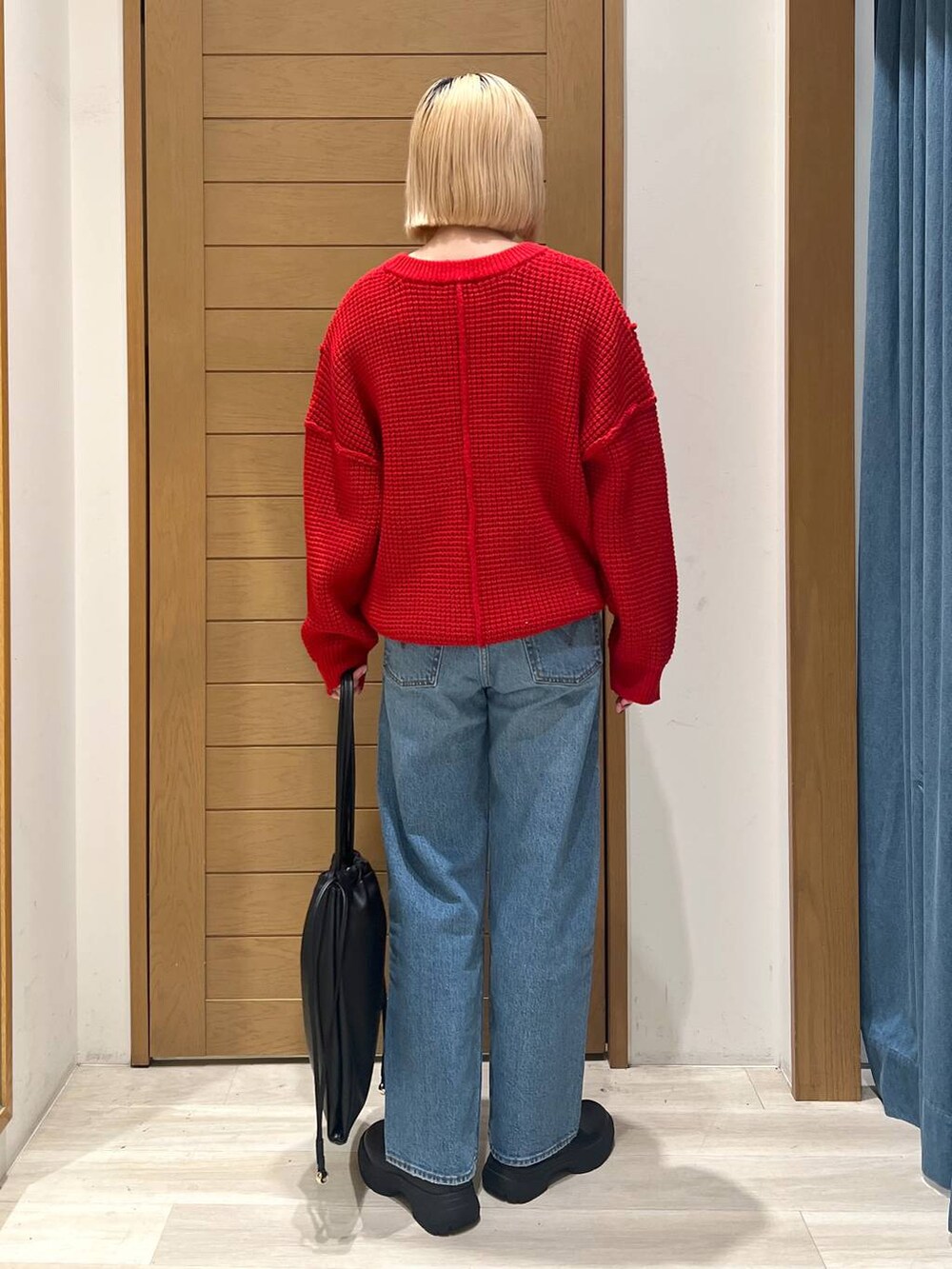 ブルー系のデニムパンツ、レッド系のニット/セーターを着用したレディースの冬コーディネートの4枚目の写真