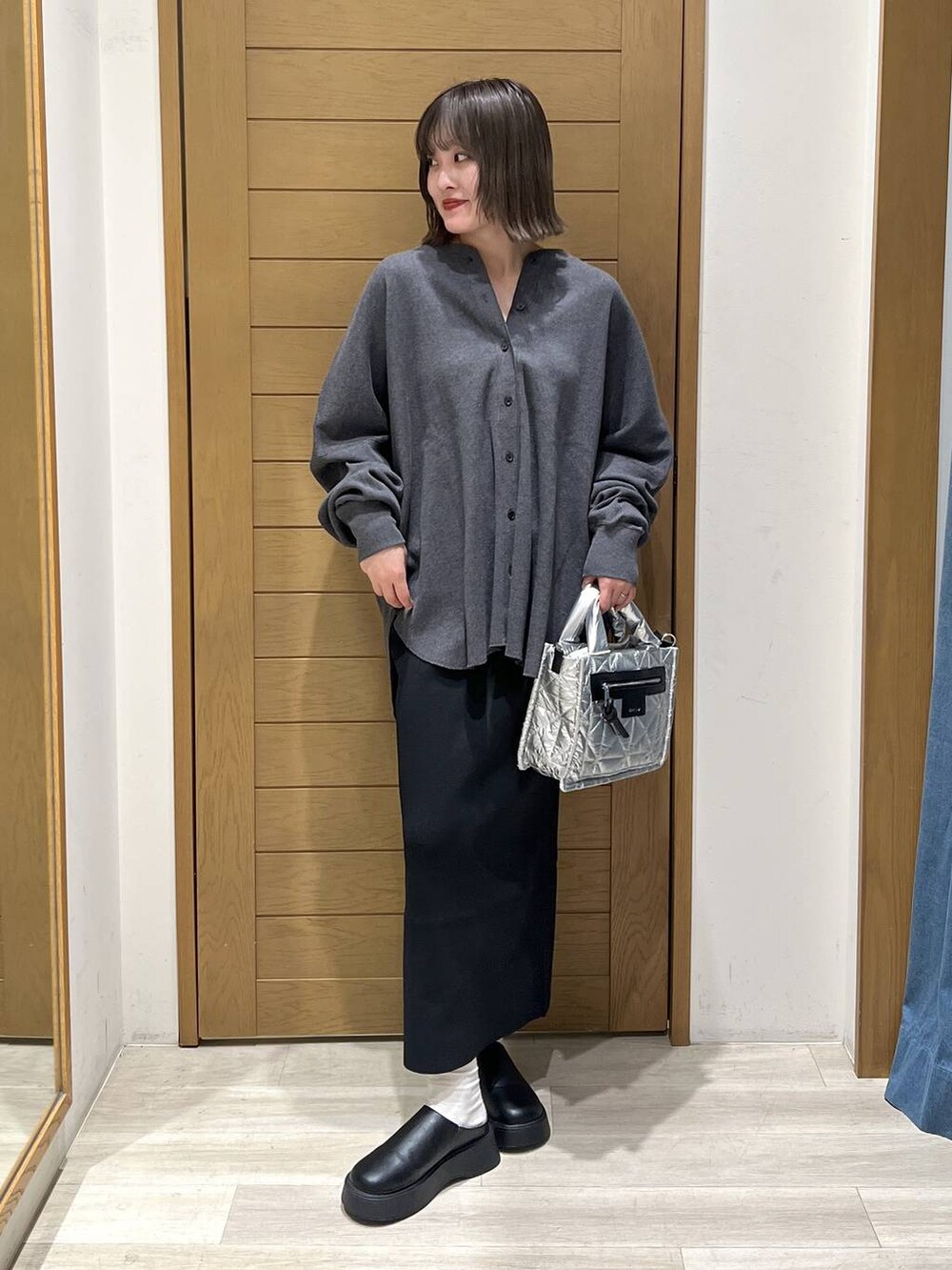 グレー系のカーディガン/ボレロ、シルバー系のショルダーバッグ、ブラック系のサンダルを着用したレディースの秋コーディネートの2枚目の写真