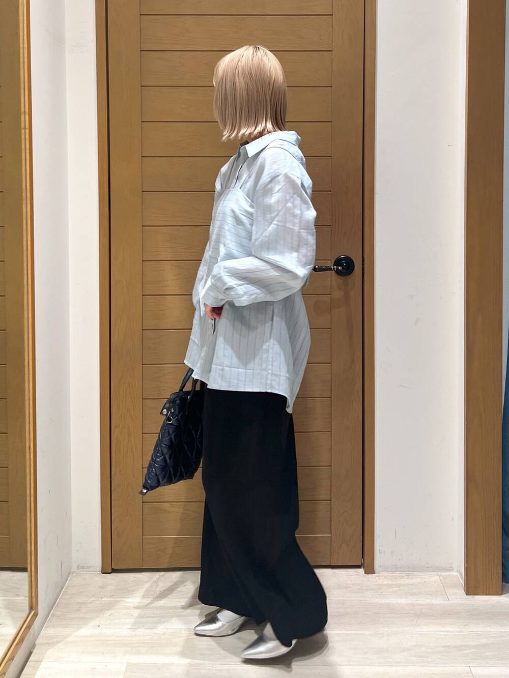 シルバー系のパンプス、ブラック系のその他パンツ、ブルー系のハンドバッグを着用したレディースの春コーディネートの4枚目の写真