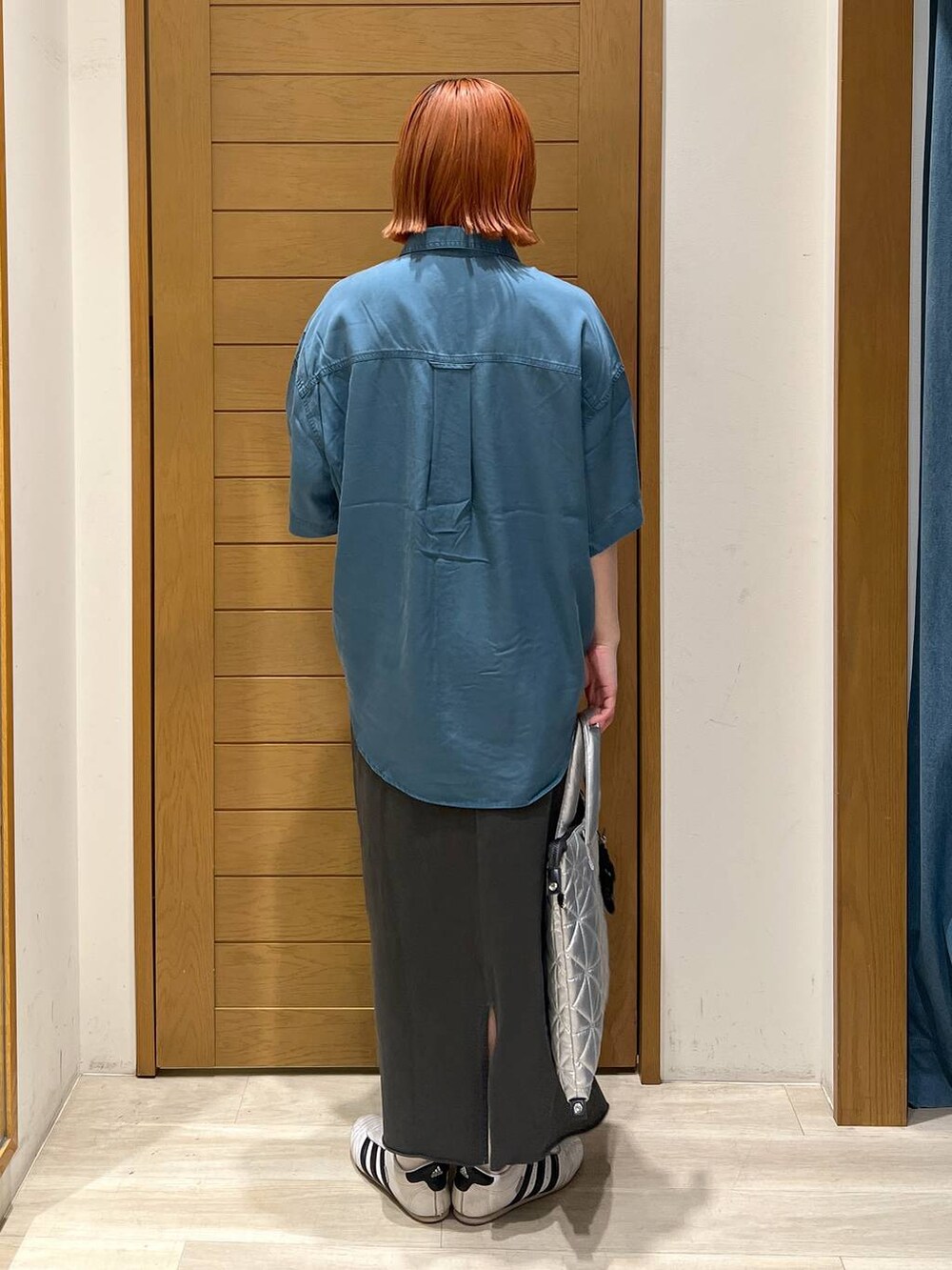 ブルー系のシャツ/ブラウス、グレー系のスカート、シルバー系のトートバッグを着用したレディースの夏コーディネートの4枚目の写真