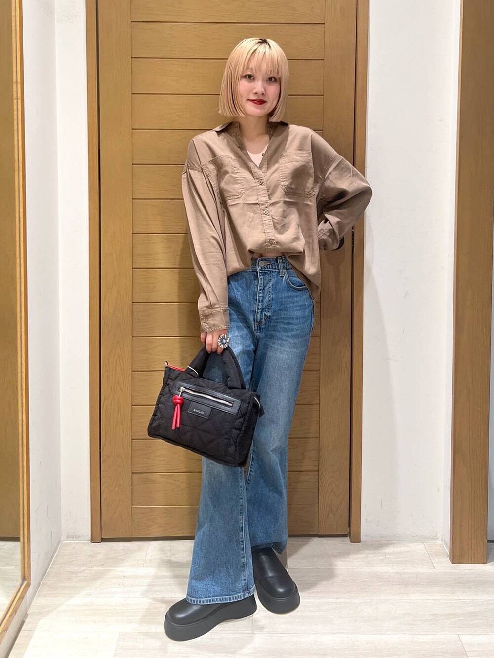 ブラック系のショルダーバッグ、ブラウン系のシャツ/ブラウス、ブルー系のデニムパンツを着用したレディースの夏コーディネートの6枚目の写真