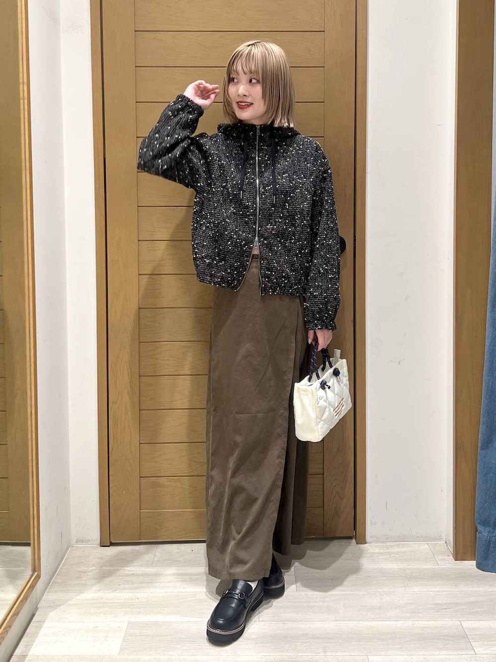 ブラック系のローファー、ブラック系のブルゾン、ホワイト系のショルダーバッグを着用したレディースの春コーディネートの5枚目の写真