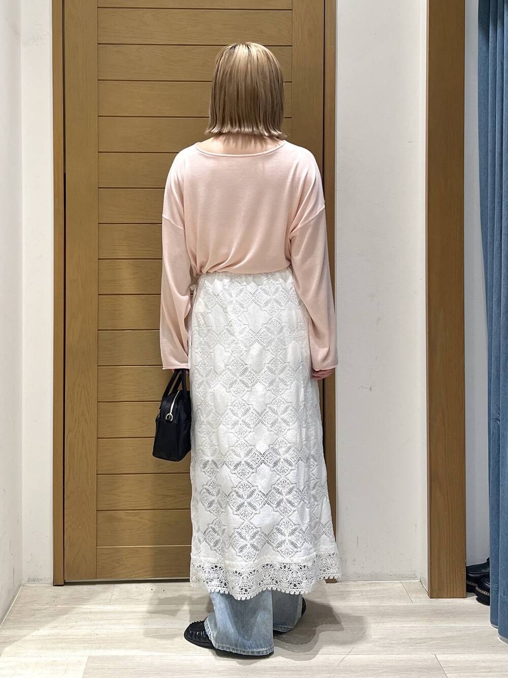 ブルー系のデニムパンツ、ブラック系のハンドバッグ、ブラック系のローファーを着用したレディースの春コーディネートの5枚目の写真