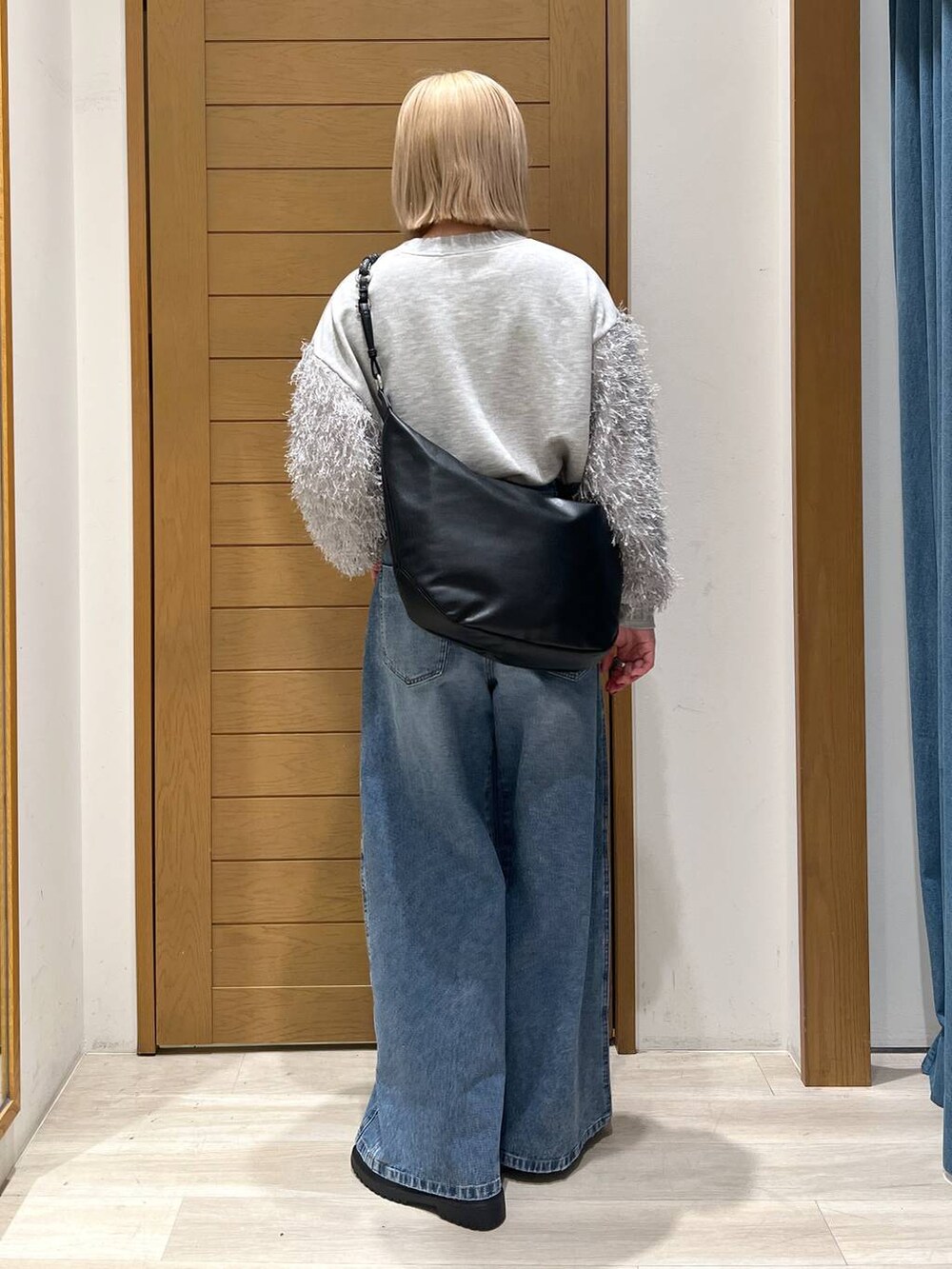 ブルー系のデニムパンツ、その他のローファー、ブラック系のショルダーバッグを着用したレディースの冬コーディネートの4枚目の写真