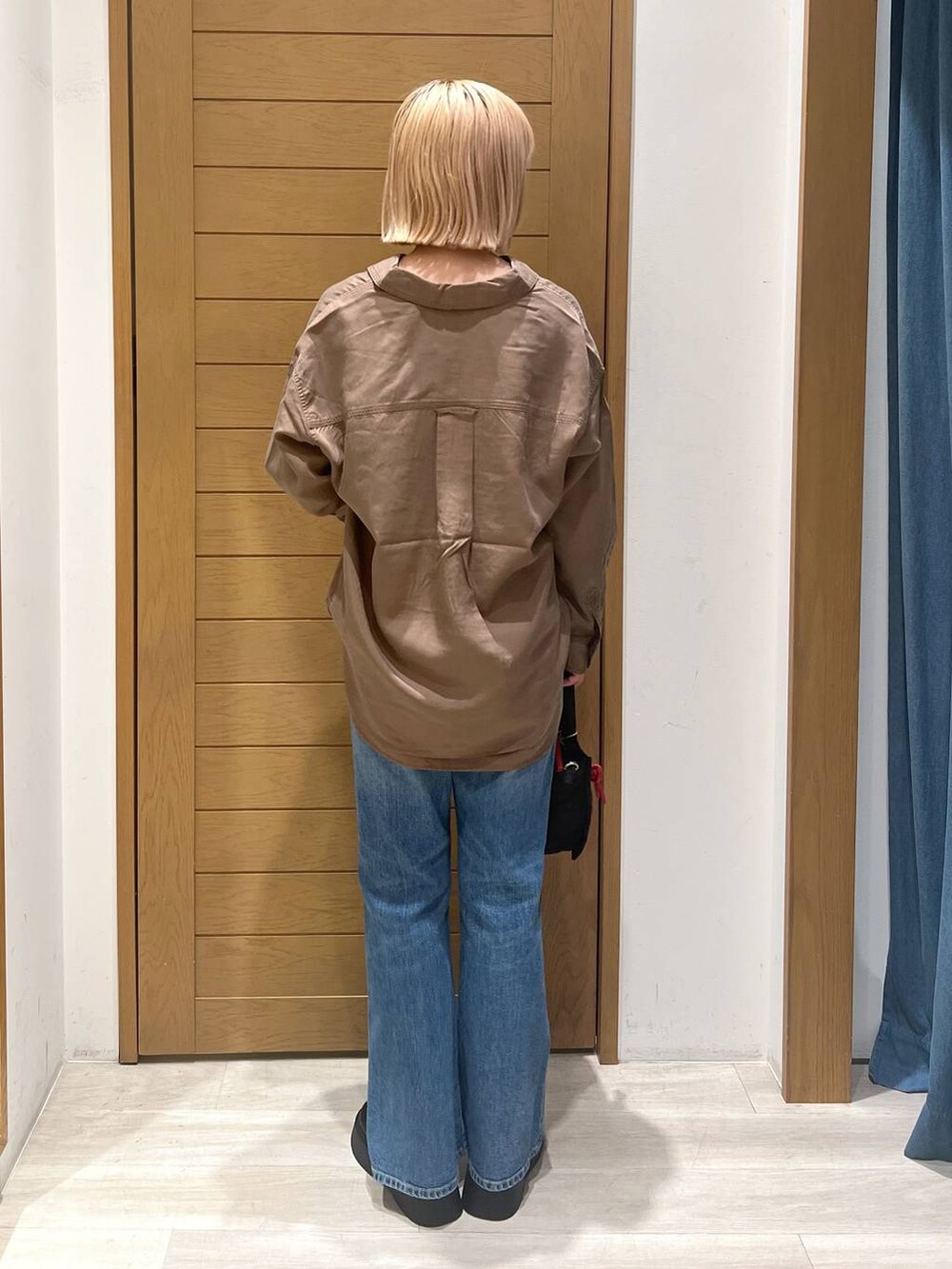 ブラック系のショルダーバッグ、ブラウン系のシャツ/ブラウス、ブルー系のデニムパンツを着用したレディースの夏コーディネートの5枚目の写真