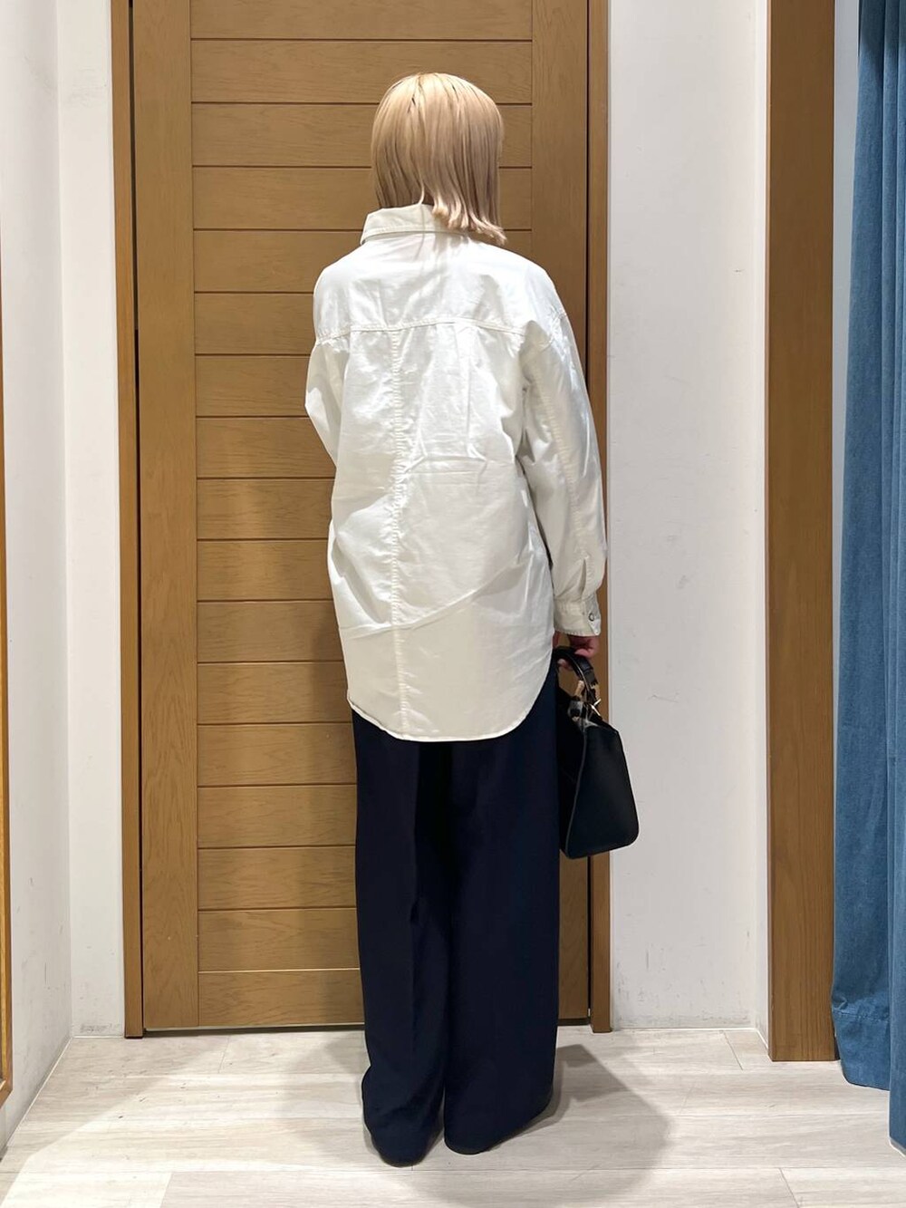 ブラック系のハンドバッグ、ブルー系のその他パンツ、その他のローファーを着用したレディースの冬コーディネートの3枚目の写真