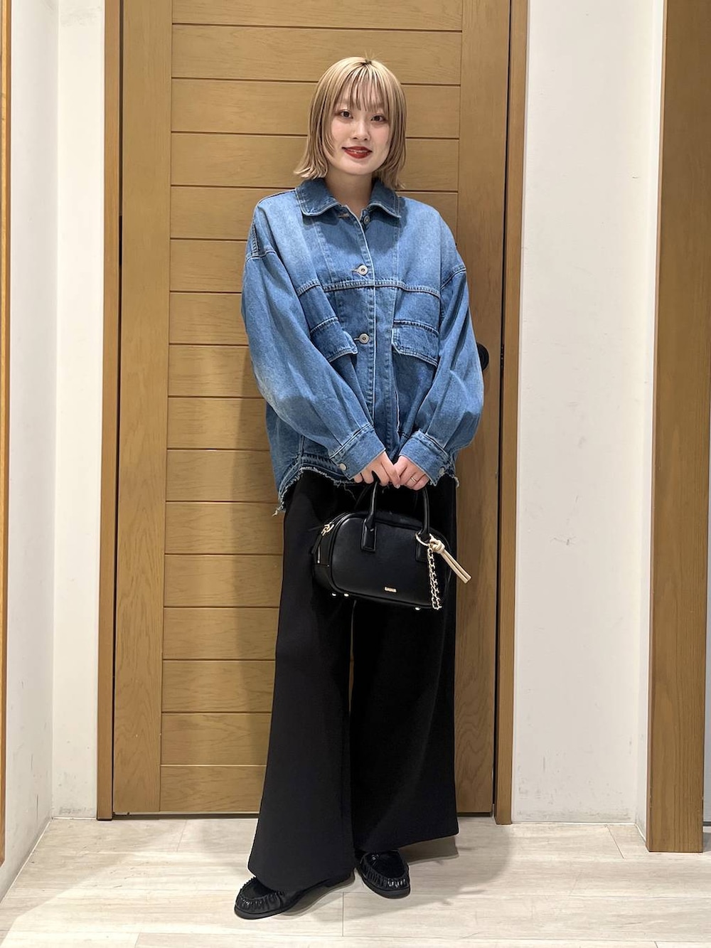 ブラック系のその他パンツ、ブラック系のローファー、ブラック系のハンドバッグを着用したレディースの春コーディネートの2枚目の写真