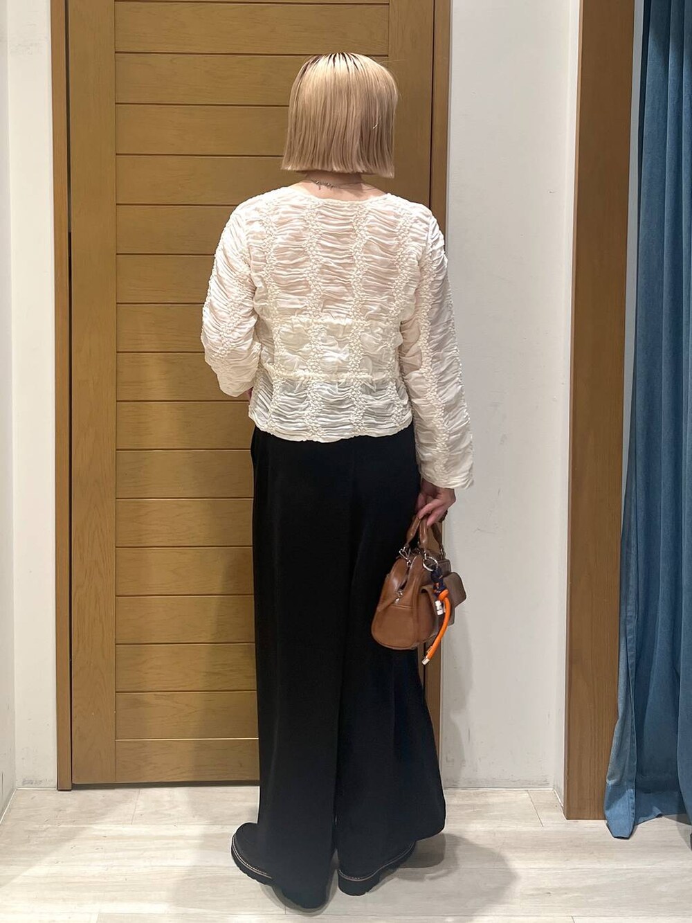 ブラック系のその他パンツ、ブラウン系のボストンバッグ、ブラック系のローファーを着用したレディースの秋コーディネートの4枚目の写真