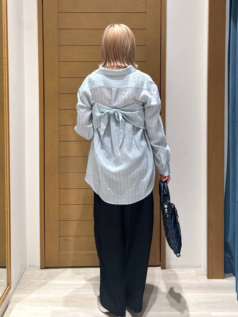 シルバー系のパンプス、ブラック系のその他パンツ、ブルー系のハンドバッグを着用したレディースの春コーディネートの5枚目の写真