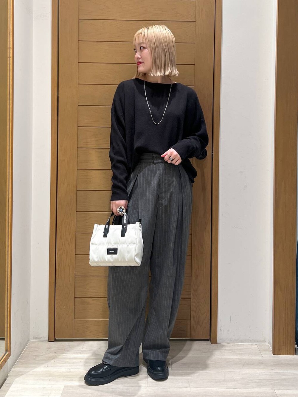 ブラック系のニット/セーター、その他のローファー、ベージュ系のショルダーバッグを着用したレディースの冬コーディネートの5枚目の写真