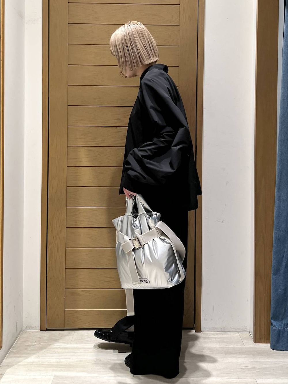 シルバー系のトートバッグ、ブラック系のローファー、ブラック系のその他パンツを着用したレディースの冬コーディネートの3枚目の写真