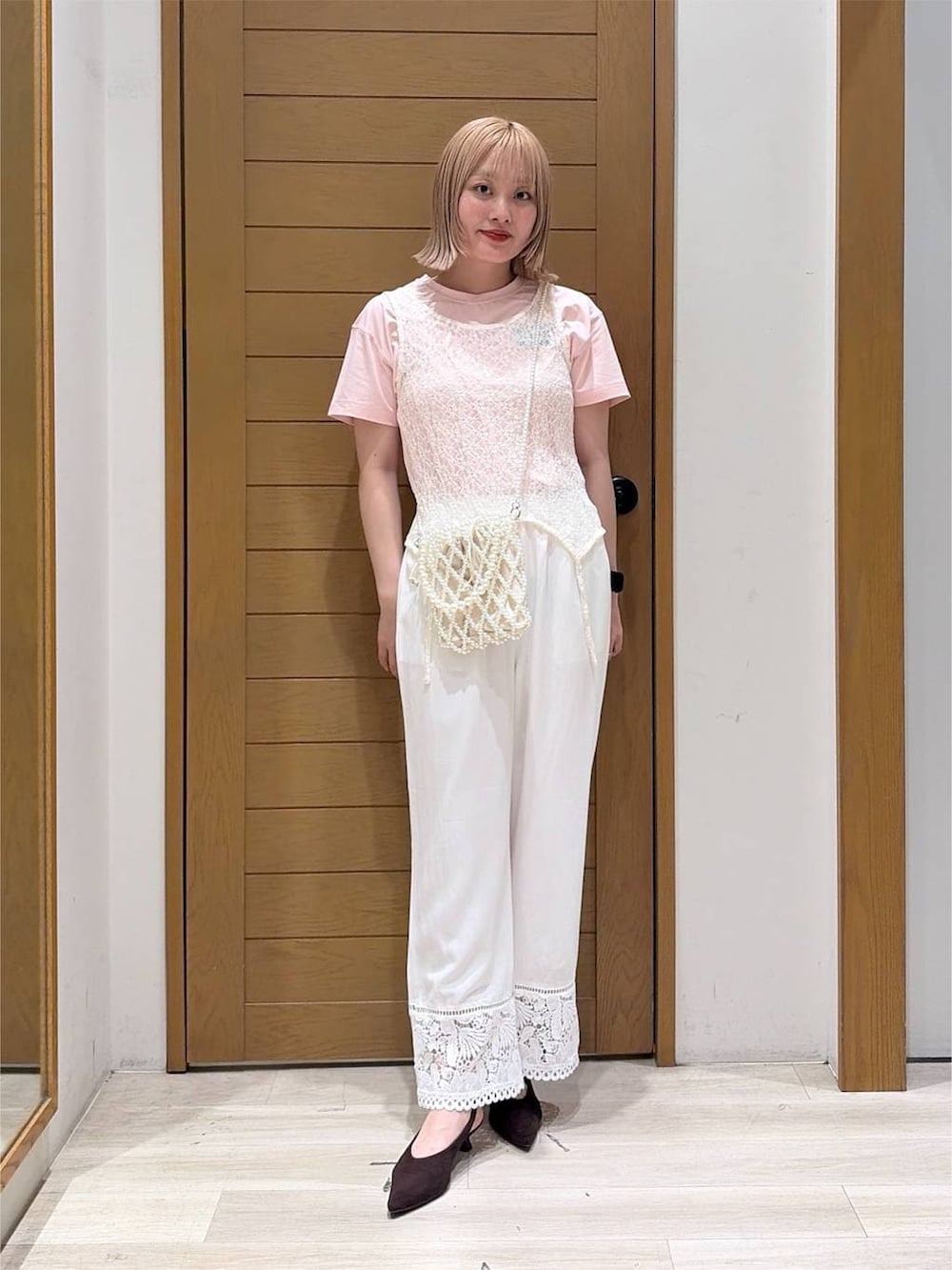 その他のショルダーバッグ、ブラウン系のパンプス、ホワイト系のタンクトップを着用したレディースの夏コーディネートの5枚目の写真