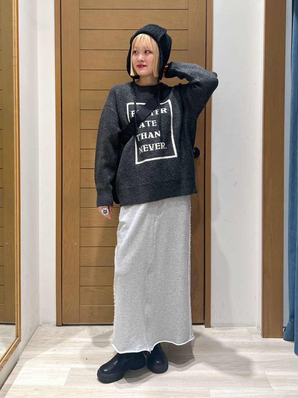 ブラック系のブーツ、グレー系のニット/セーター、ブラック系のショルダーバッグを着用したレディースの冬コーディネートの3枚目の写真