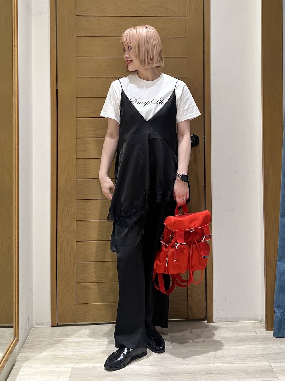 レッド系のバックパック/リュック、ブラック系のキャミソール、ホワイト系のTシャツ/カットソーを着用したレディースの春コーディネートの2枚目の写真