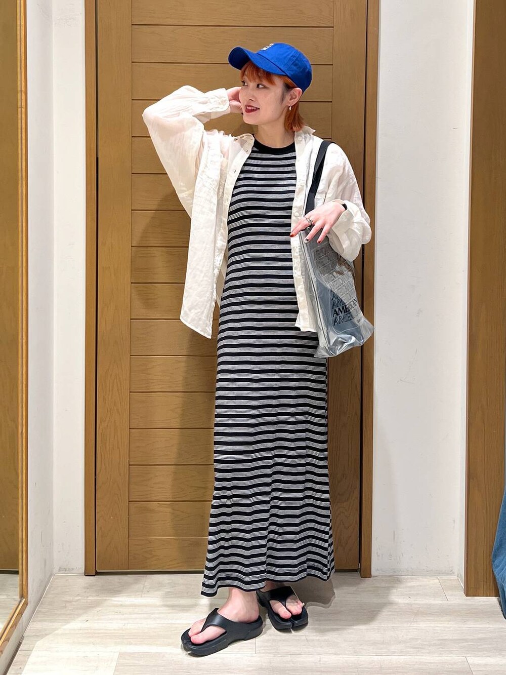 ブラック系のサンダル、ホワイト系のシャツ/ブラウス、シルバー系のトートバッグを着用したレディースの夏コーディネートの2枚目の写真