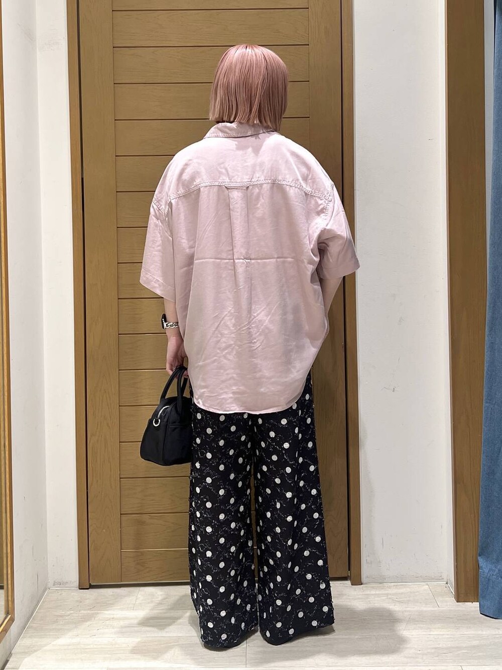 パープル系のシャツ/ブラウス、ブラック系のパンプス、ブラック系のハンドバッグを着用したレディースの春コーディネートの5枚目の写真