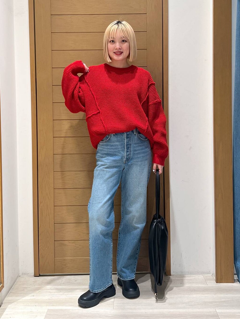 ブルー系のデニムパンツ、レッド系のニット/セーターを着用したレディースの冬コーディネートの5枚目の写真