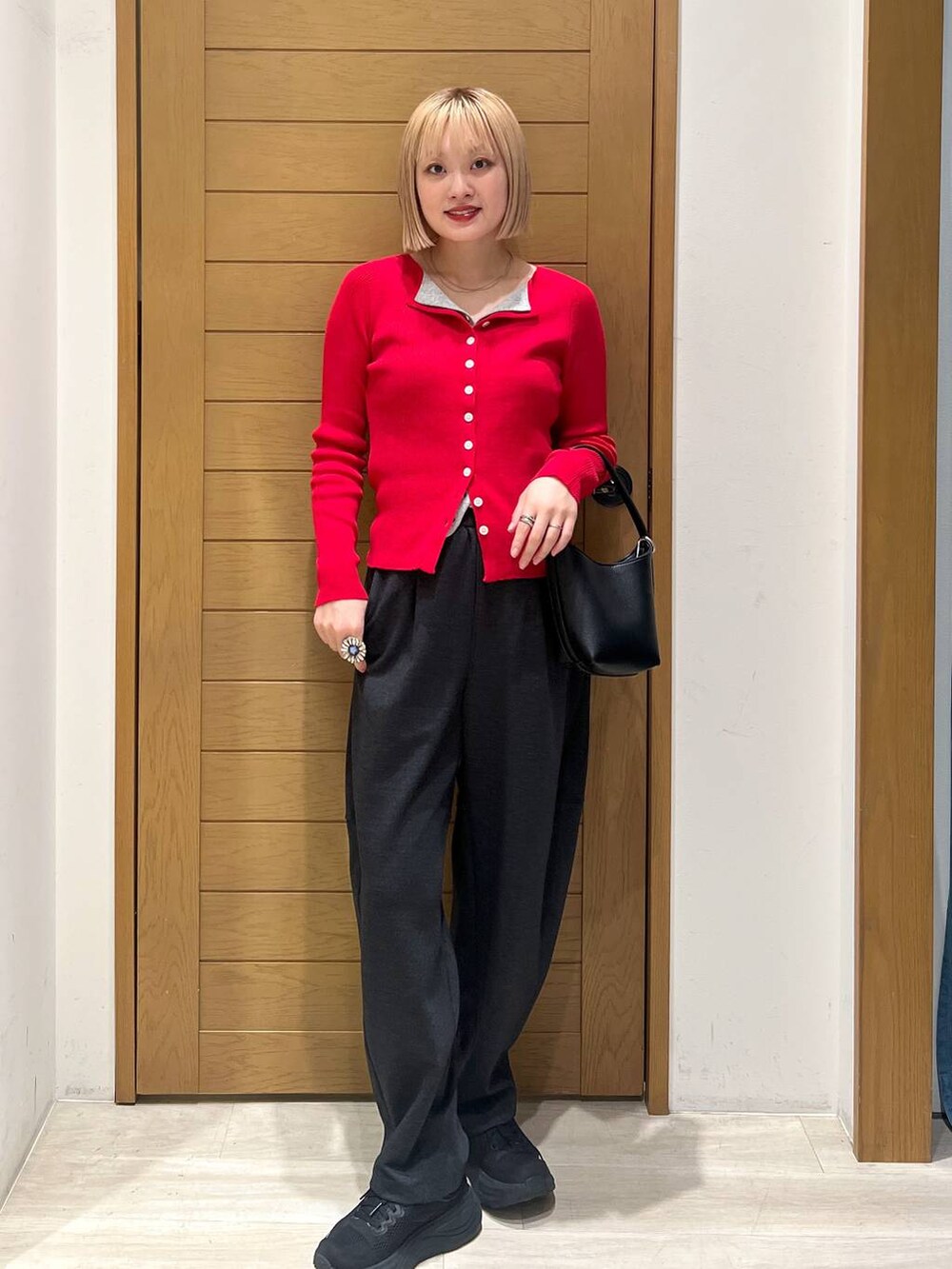 ブラック系のハンドバッグ、グレー系のカーディガン/ボレロ、グレー系のその他パンツを着用したレディースの秋コーディネートの5枚目の写真