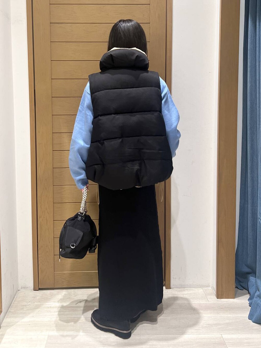 ブルー系のニット/セーター、ブラック系のローファー、ブラック系のハンドバッグを着用したレディースの秋コーディネートの5枚目の写真