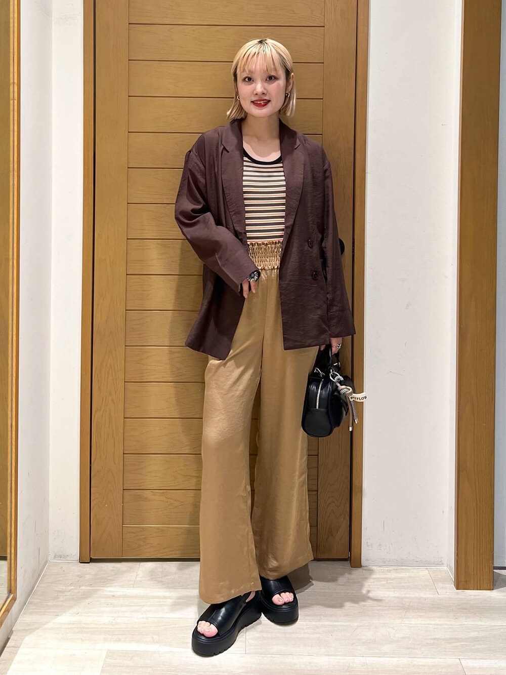ブラック系のボストンバッグ、ブラウン系のその他パンツ、ブラウン系のテーラードジャケットを着用したレディースの夏コーディネートの5枚目の写真