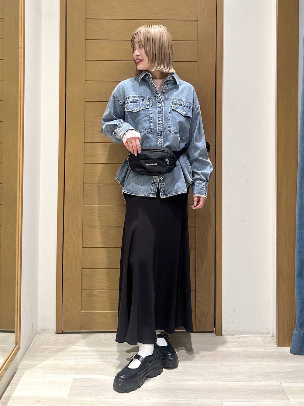 ブルー系のシャツ/ブラウス、ブラック系のスニーカー、ピンク系のニット/セーターを着用したレディースの春コーディネートの2枚目の写真