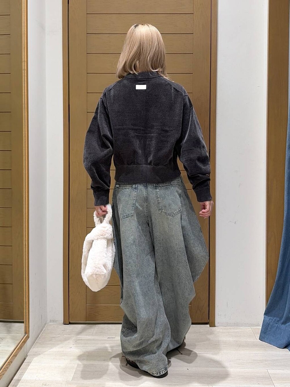 その他のその他シューズ、ベージュ系のハンドバッグ、ブルー系のデニムパンツを着用したレディースの秋コーディネートの4枚目の写真