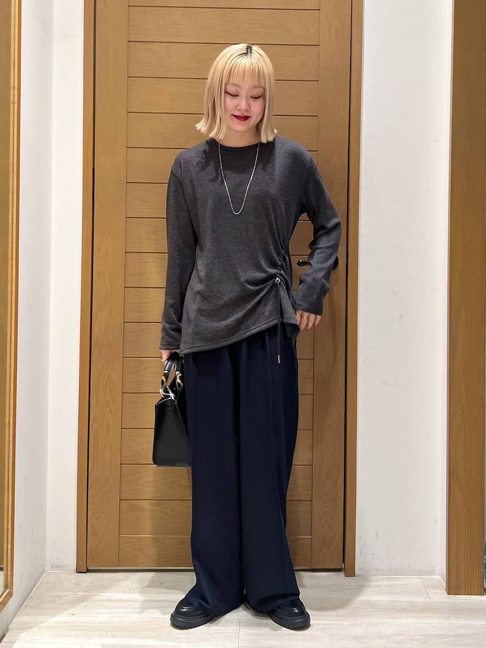 ブラック系のハンドバッグ、ブルー系のその他パンツ、その他のローファーを着用したレディースの冬コーディネートの5枚目の写真