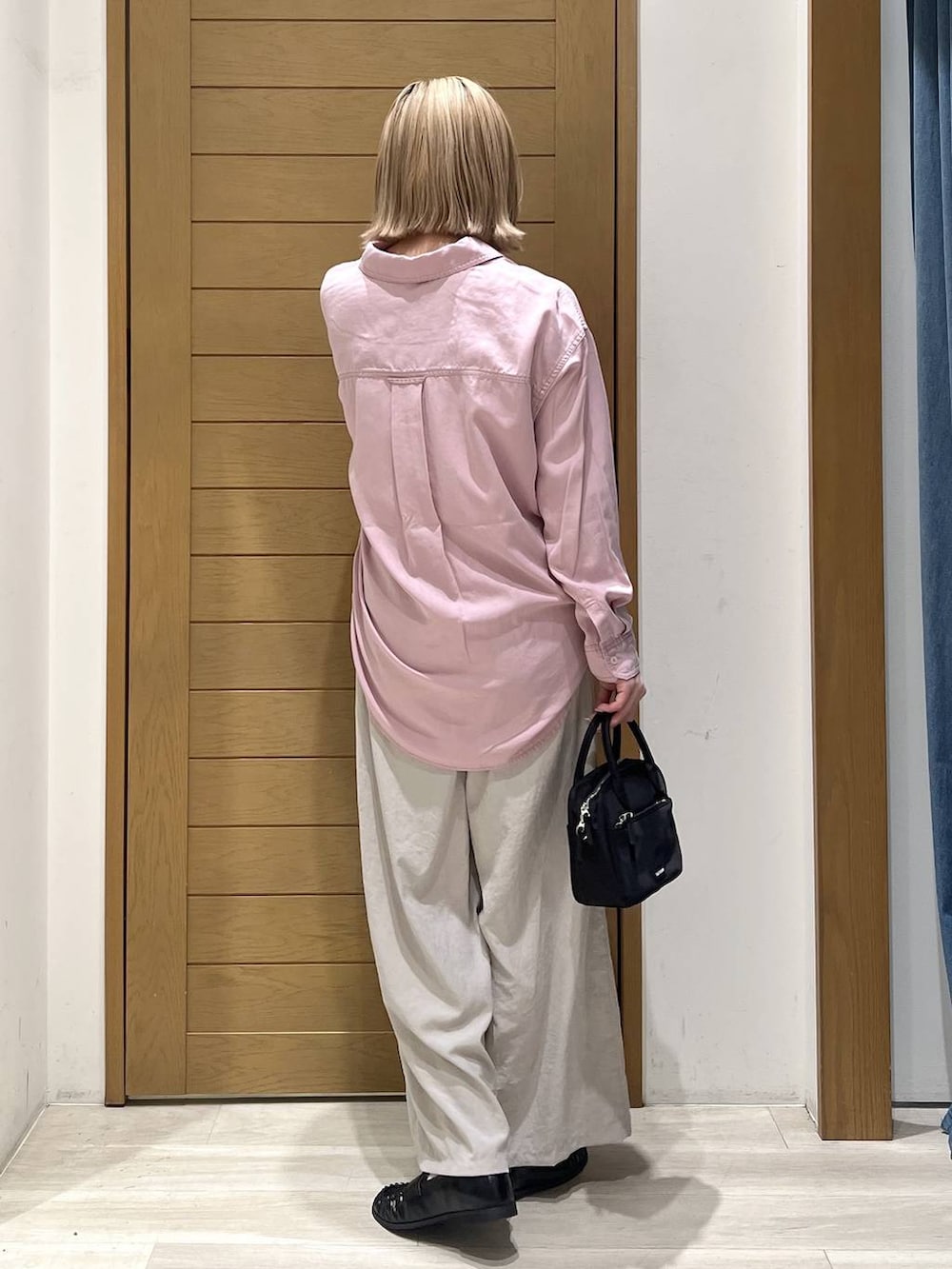 ピンク系のシャツ/ブラウス、ブラック系のハンドバッグ、ブラック系のローファーを着用したレディースの春コーディネートの5枚目の写真