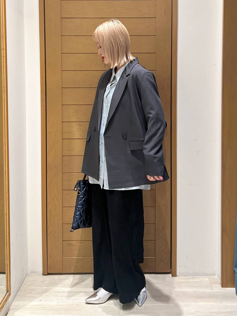 シルバー系のパンプス、ブラック系のその他パンツ、ブルー系のハンドバッグを着用したレディースの春コーディネートの3枚目の写真