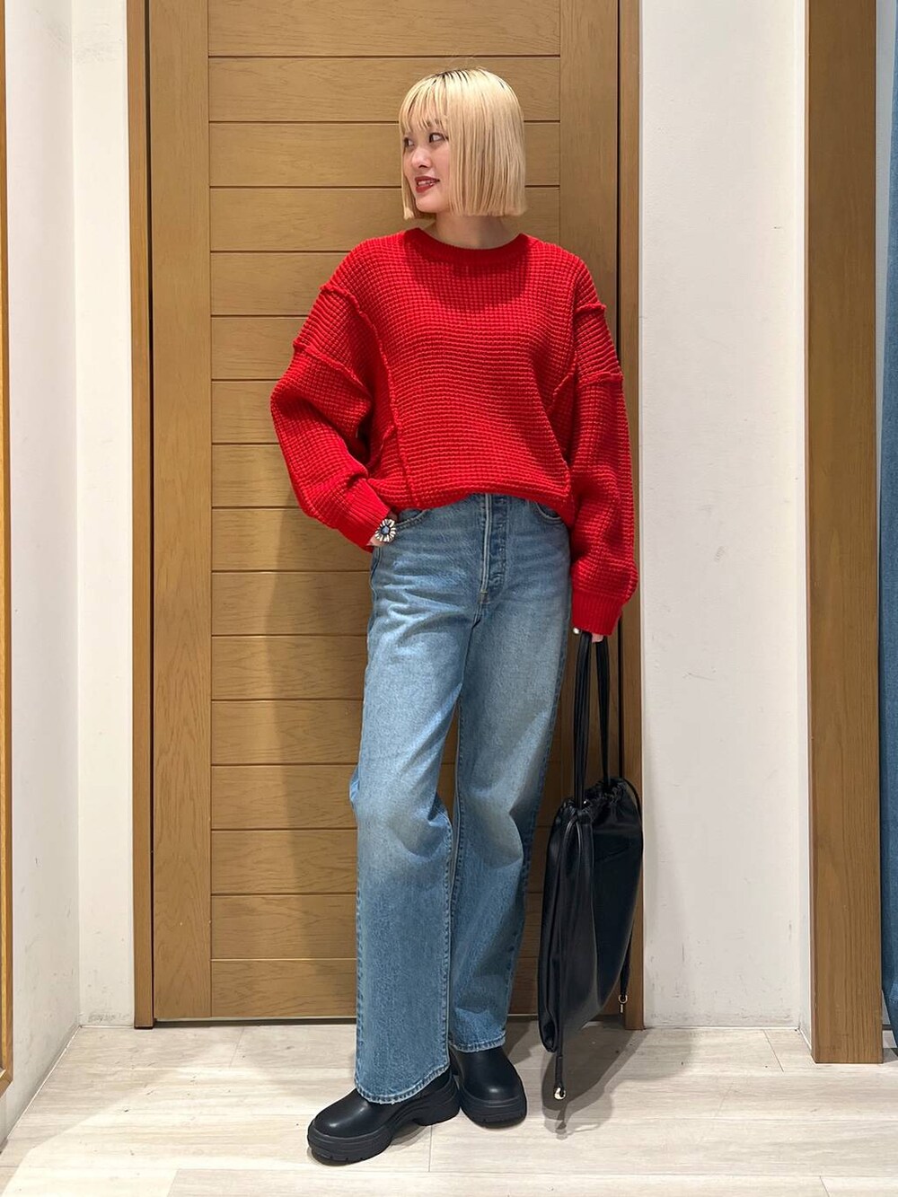 ブルー系のデニムパンツ、レッド系のニット/セーターを着用したレディースの冬コーディネートの2枚目の写真