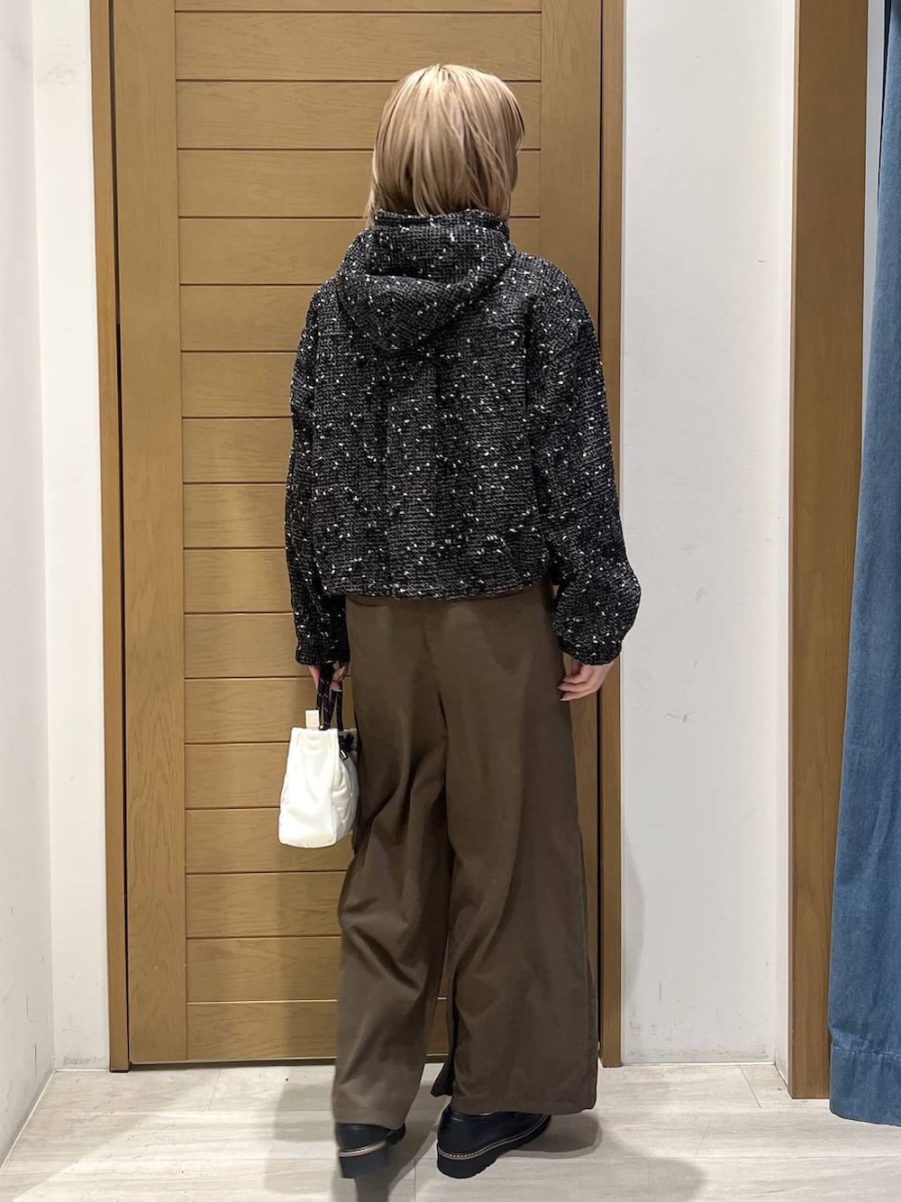 ブラック系のローファー、ブラック系のブルゾン、ホワイト系のショルダーバッグを着用したレディースの春コーディネートの4枚目の写真