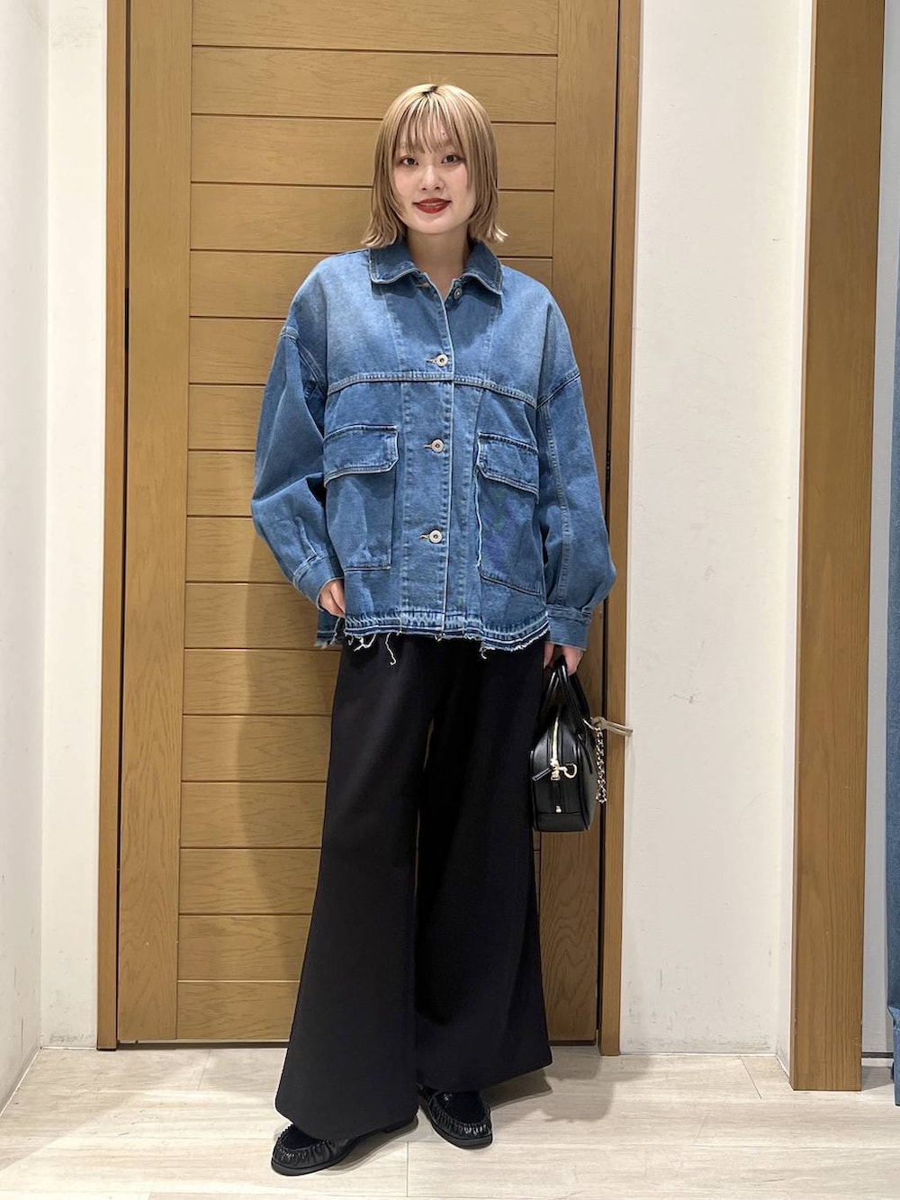 ブラック系のその他パンツ、ブラック系のローファー、ブラック系のハンドバッグを着用したレディースの春コーディネートの5枚目の写真