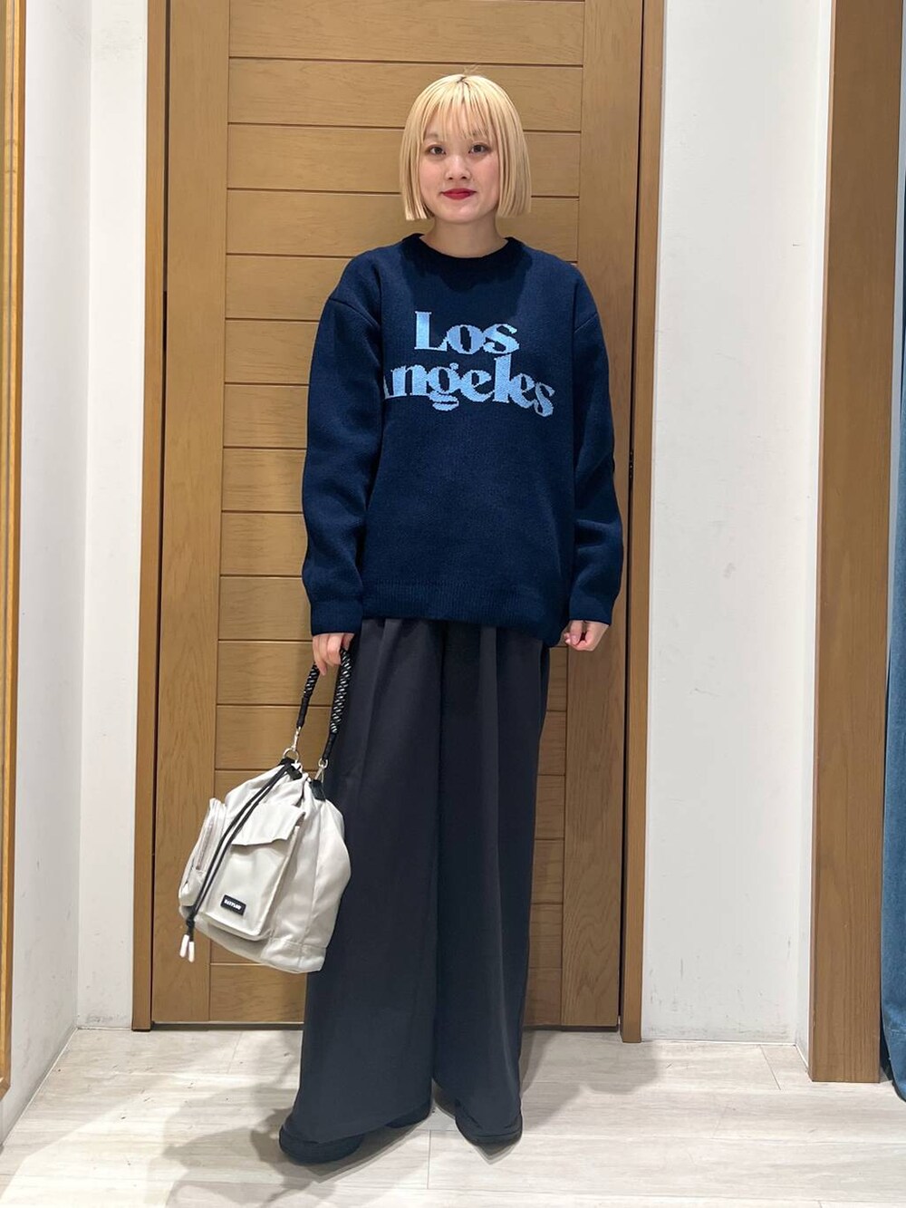 グレー系のショルダーバッグ、ブラック系のブーツ、ブラック系のその他パンツを着用したレディースの冬コーディネートの2枚目の写真