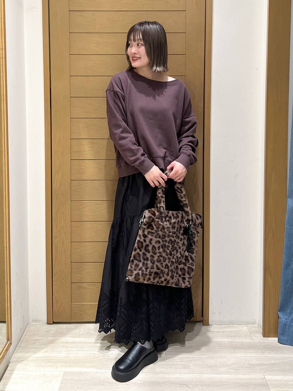 ブラック系のサンダル、ブラウン系のトートバッグ、ブラウン系のスウェットを着用したレディースの秋コーディネートの2枚目の写真