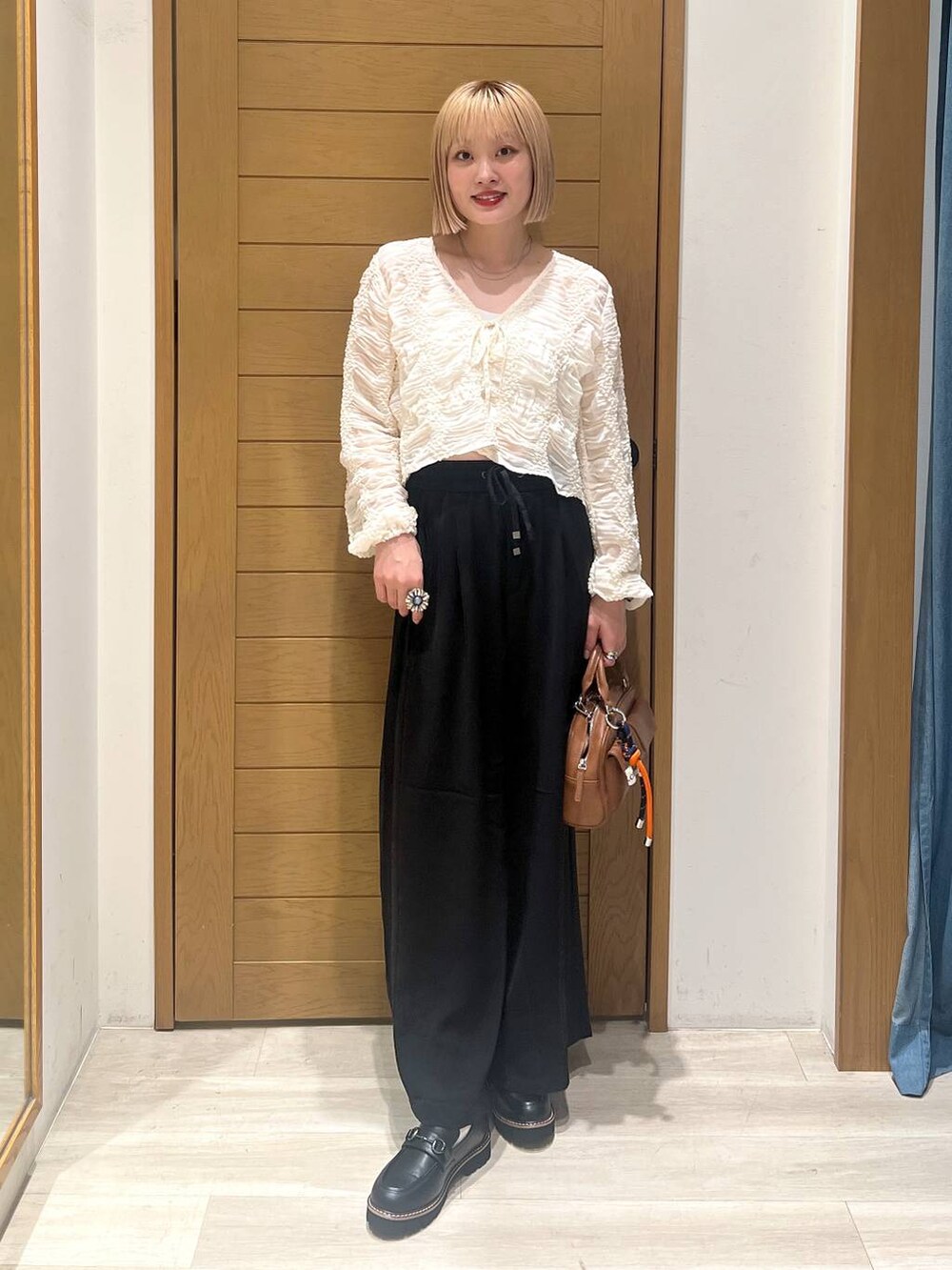 ブラック系のその他パンツ、ブラウン系のボストンバッグ、ブラック系のローファーを着用したレディースの秋コーディネートの5枚目の写真