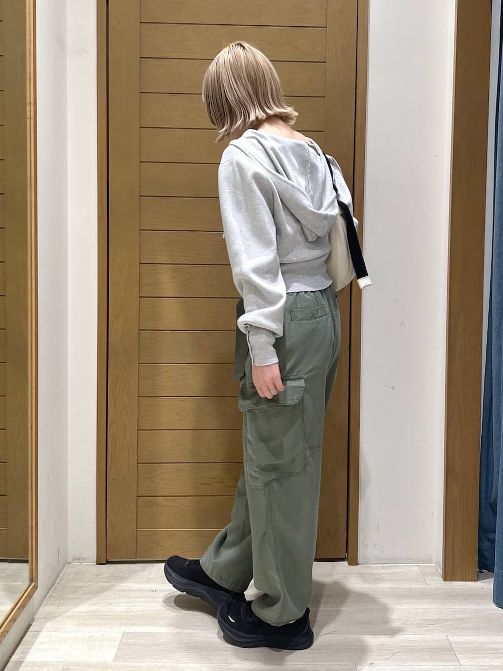 グリーン系のカーゴパンツ、ホワイト系のショルダーバッグ、グレー系のパーカーを着用したレディースの春コーディネートの4枚目の写真