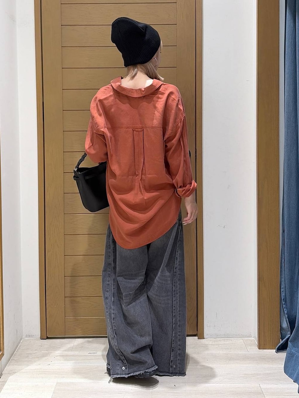 ブラック系のスニーカー、ブラック系のデニムパンツ、ブラウン系のシャツ/ブラウスを着用したレディースの秋コーディネートの3枚目の写真